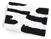 Load image into Gallery viewer, Reversible black and white knit baby blanket folded, modern abstract design by Wren & Rumor